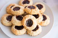 a white plate topped with cookies covered in jelly filling toppings on top of a table