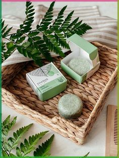 two soaps sitting on top of a wicker tray next to a green plant