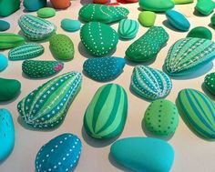 many different colored rocks on a table with polka dot dots and green, blue, and white designs