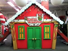 a red and green building with santa's workshop on top