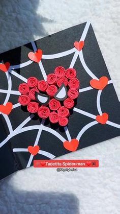 a handmade valentine's day card with red paper roses in the shape of a heart