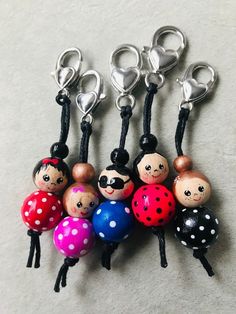 a bunch of little ladybug key chains on a white surface with polka dots