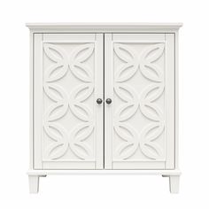 a white cabinet with two doors and an ornate design on the front, against a white background