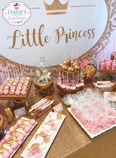 a table topped with lots of pink and gold desserts