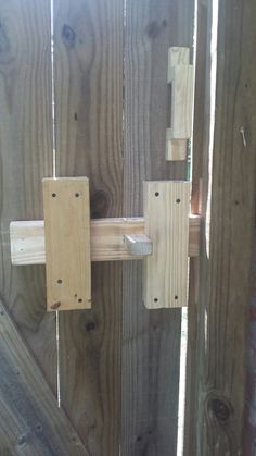 a close up of a wooden gate with two latches on the front and back