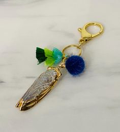 a keychain with two tassels and a blue pom - pom