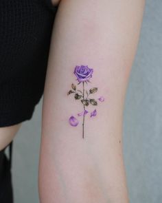 a purple rose tattoo on the left arm