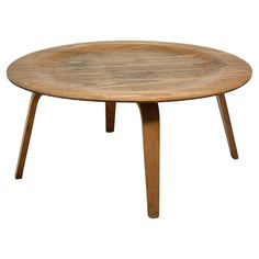 an oval wooden table with two legs and a small round tray on the top that is made out of wood