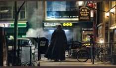 a man dressed as darth vader walking down the street