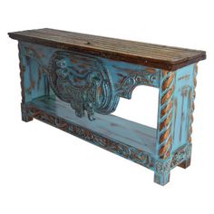 an old wooden bench with carvings on the front and back legs, painted blue to look like wood