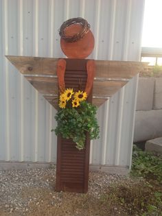 the sunflowers are growing on top of the wooden sign with a cowboy hat