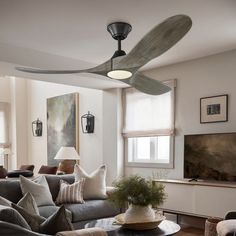 a living room filled with furniture and a ceiling fan in the middle of the room