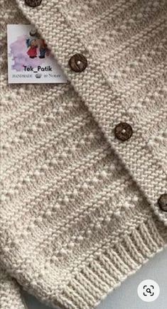 a close up of a sweater with buttons on it