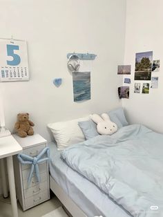 a bedroom with a bed, desk and stuffed animal on it's headboard