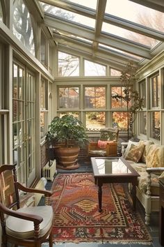 a living room filled with lots of furniture next to a window covered in glass walls