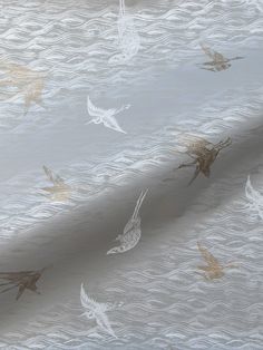 a white and gold wallpaper with birds flying in the air on it's side