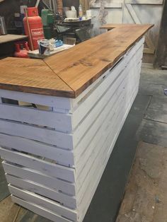 a bar made out of pallet wood in a garage with tools on the counter