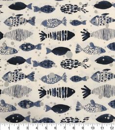 a blue and white fish print fabric with black dots on the bottom, in front of a ruler