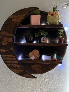 a wooden shelf with various items on it and lights around the shelves in front of it