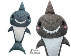 two stuffed animals that look like sharks with big eyes and sharp teeth are standing next to each other