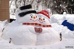 two snowmen in the middle of a pile of snow