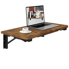 an open laptop computer sitting on top of a wooden table with a dog in the screen