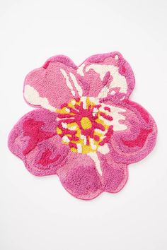 a pink flower with white and yellow centers on a white background is featured in this image