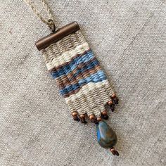 a piece of fabric with beads hanging from it's end on a necklace chain