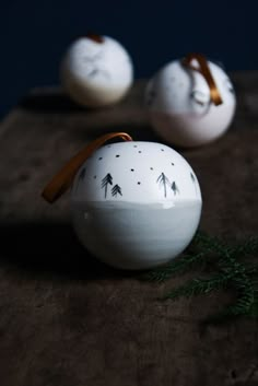 three white ceramic ornaments sitting on top of a wooden table