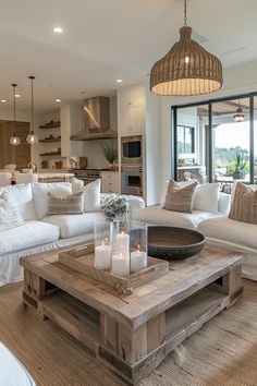 a living room filled with lots of white furniture and candles on top of a coffee table