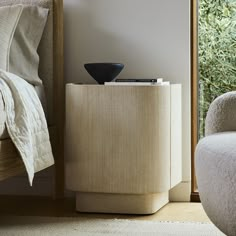 a bedroom with a bed, chair and side table