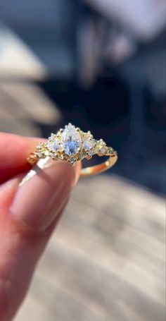 a person is holding an engagement ring with two stones on it and the other side