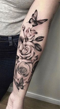 a woman's arm with roses and butterflies on it, in black and white