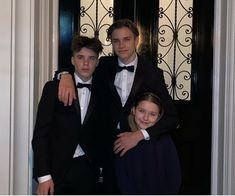 three young men in tuxedos standing next to each other at the door way