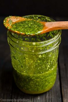 a jar filled with green pestle and a wooden spoon