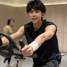 a young man riding an exercise bike in a gym