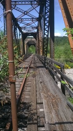 an old wooden bridge with metal support beams