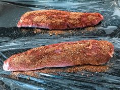 two steaks are cooking on the grill in plastic wrappers and ready to be cooked