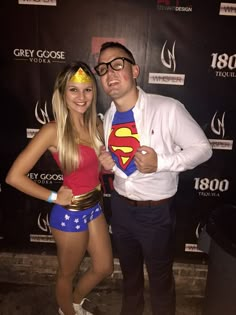 a man standing next to a woman wearing a superman costume