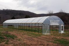 a large green house sitting on top of a lush green field