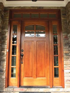 the front door is made of wood and has two sidelights on either side of it