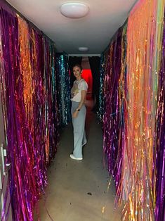 a woman standing in the middle of a room filled with streamers