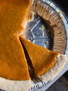 two slices of pumpkin pie sitting on top of each other in a metal pan with tin foil