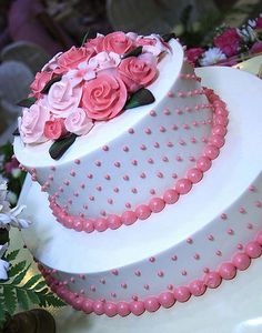 a three tiered cake with pink flowers on top