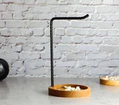 a wooden bowl filled with popcorn next to a black object on top of a table