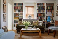 a living room filled with furniture and lots of books