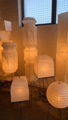 many white lanterns are lit up in front of a window