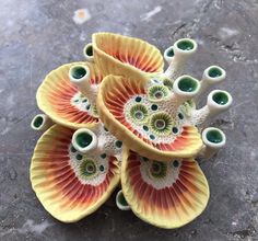 a group of ceramic flowers sitting on top of a stone floor next to each other