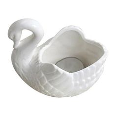 a white swan shaped bowl sitting on top of a table