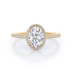 a yellow and white gold engagement ring with an oval cut diamond surrounded by pave diamonds